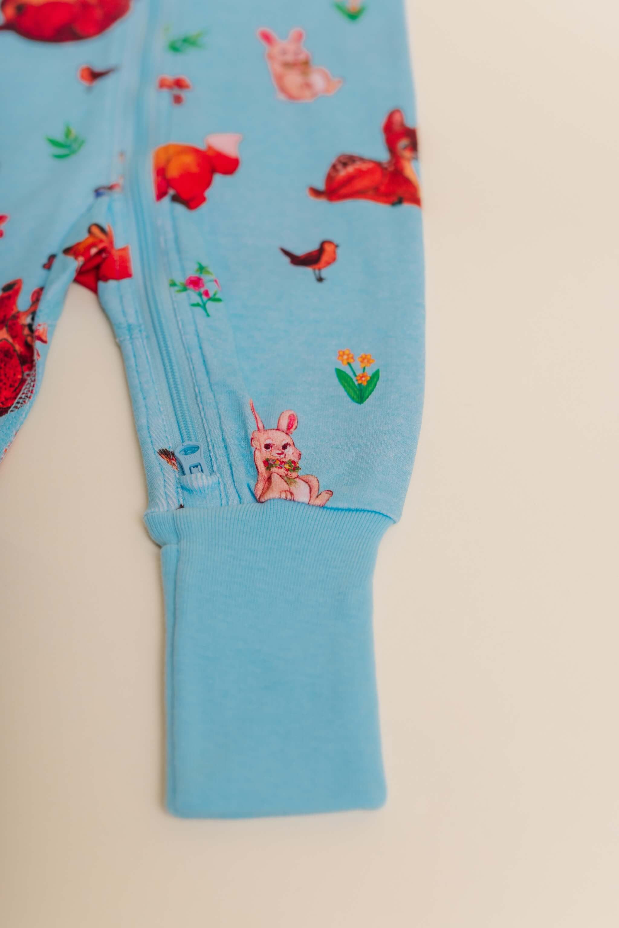 organic cotton baby zipper sleeper with fold-over cuffs in blue animal print designed by anna iwin