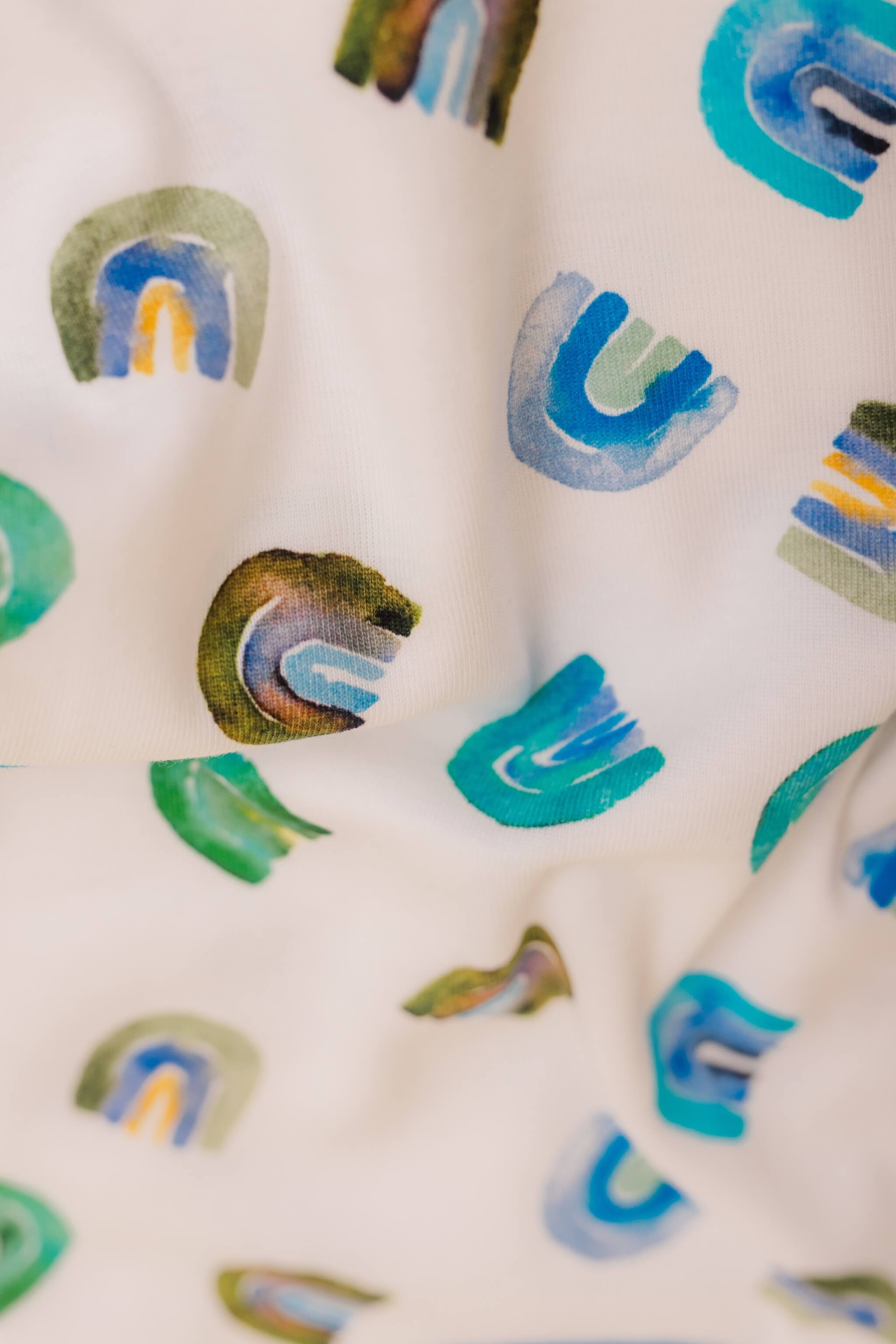 organic cotton baby zipper sleeper with fold-over cuffs in blue rainbow print designed by madeline kerrii