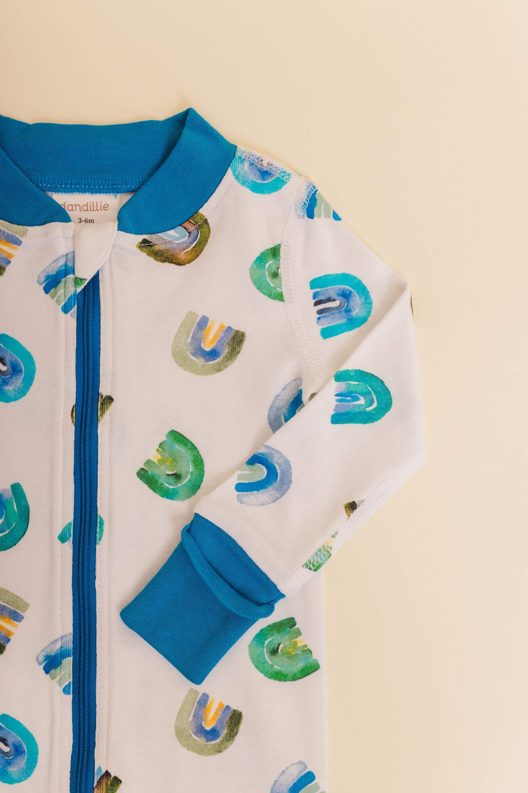 organic cotton baby zipper sleeper with fold-over cuffs in blue rainbow print designed by madeline kerrii