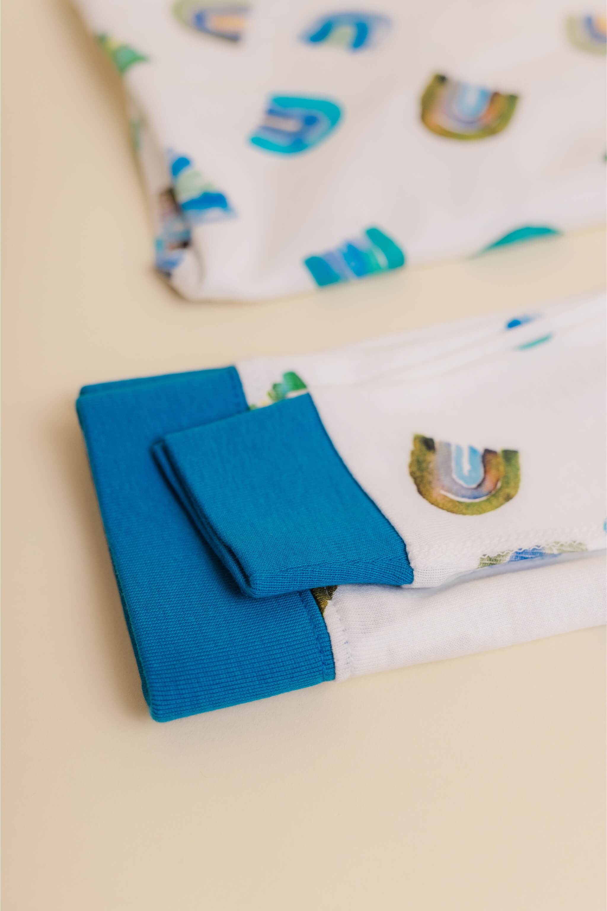 organic cotton children's long sleeve sleepwear in blue rainbow print designed by madeline kerrii