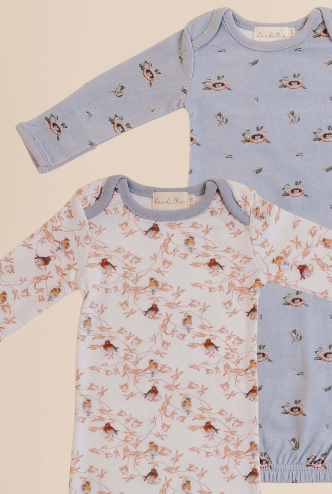 Two baby gowns with bird pattern on a beige and blue background