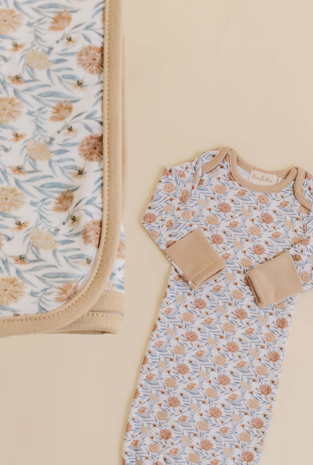 Baby gown with floral pattern on a beige background and swaddle