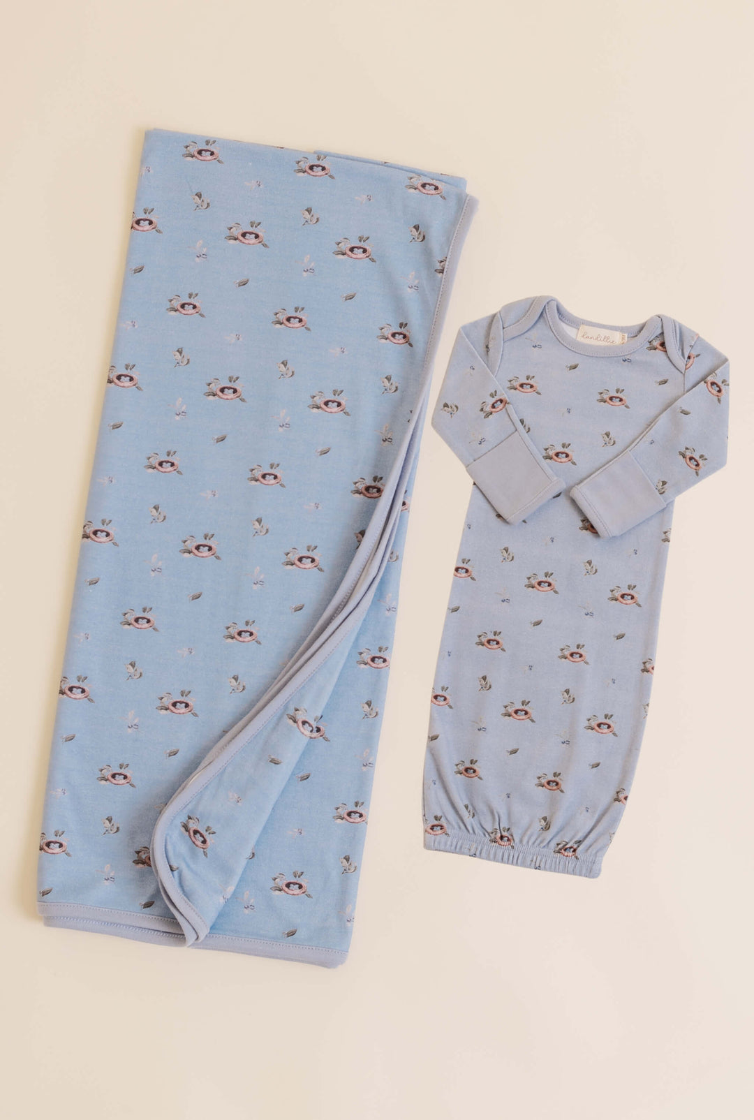 Baby swaddle and outfit set with bird pattern on a blue background
