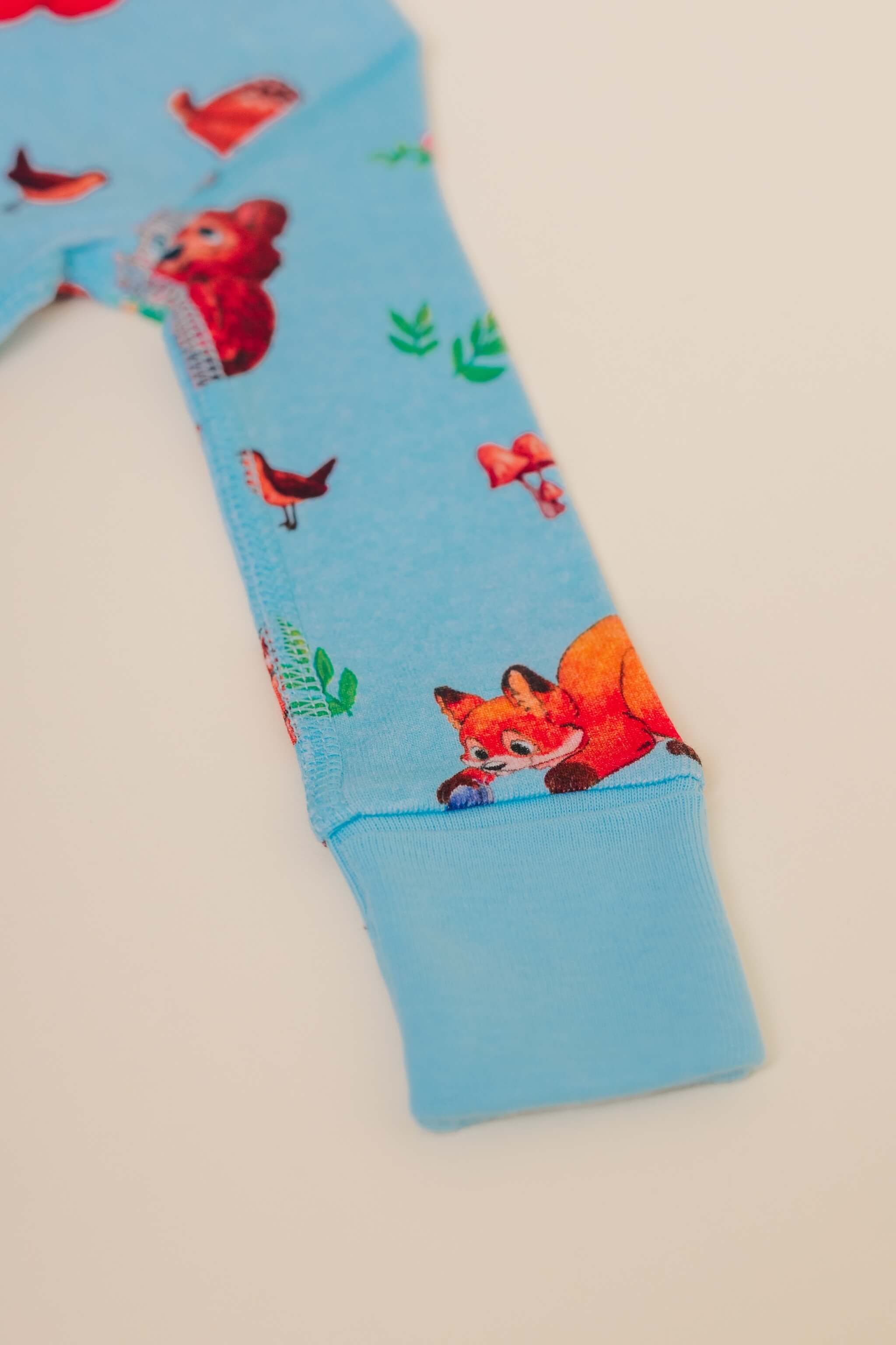 organic cotton baby zipper sleeper with fold-over cuffs in blue animal print designed by anna iwin