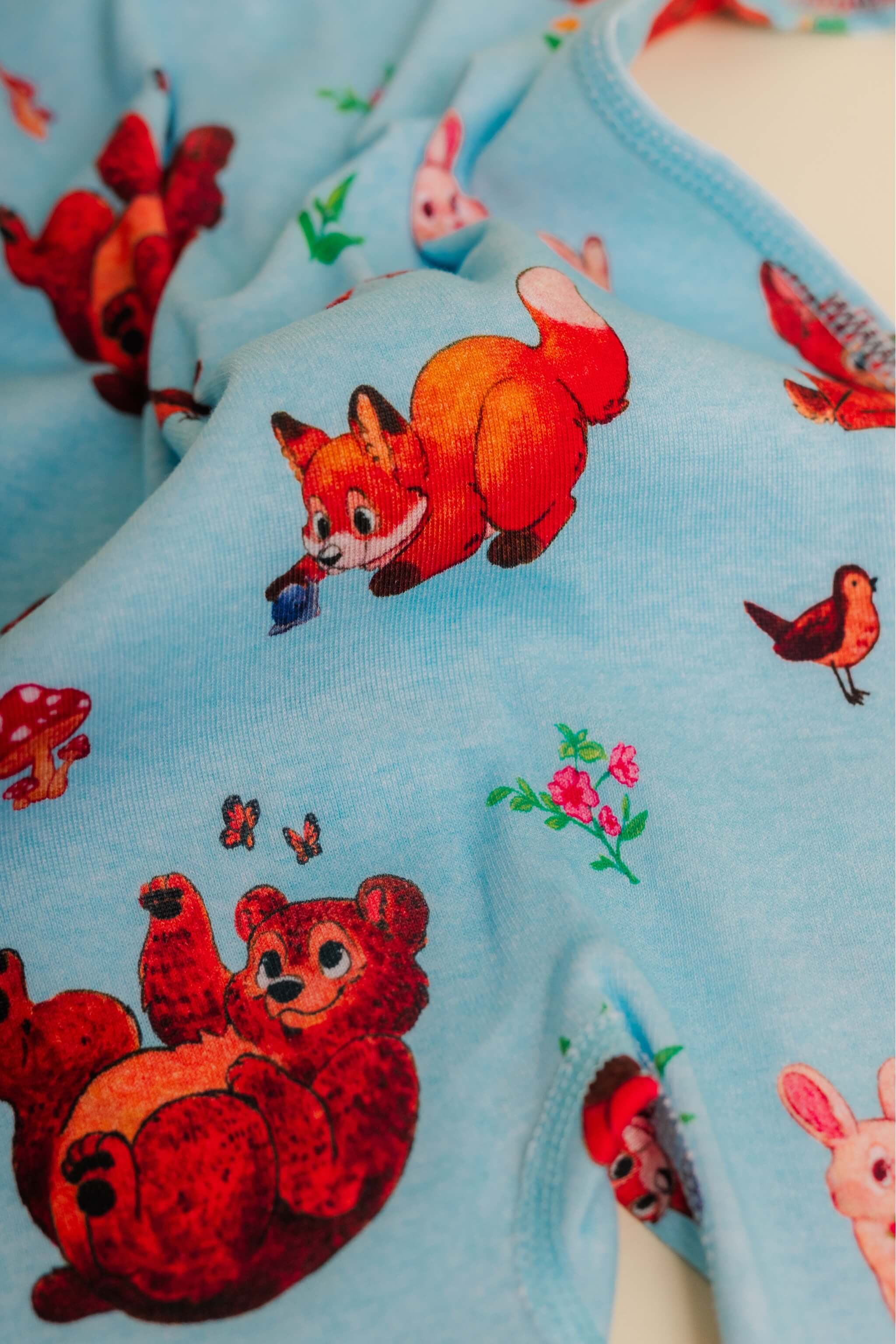 organic cotton baby zipper sleeper with fold-over cuffs in blue animal print designed by anna iwin