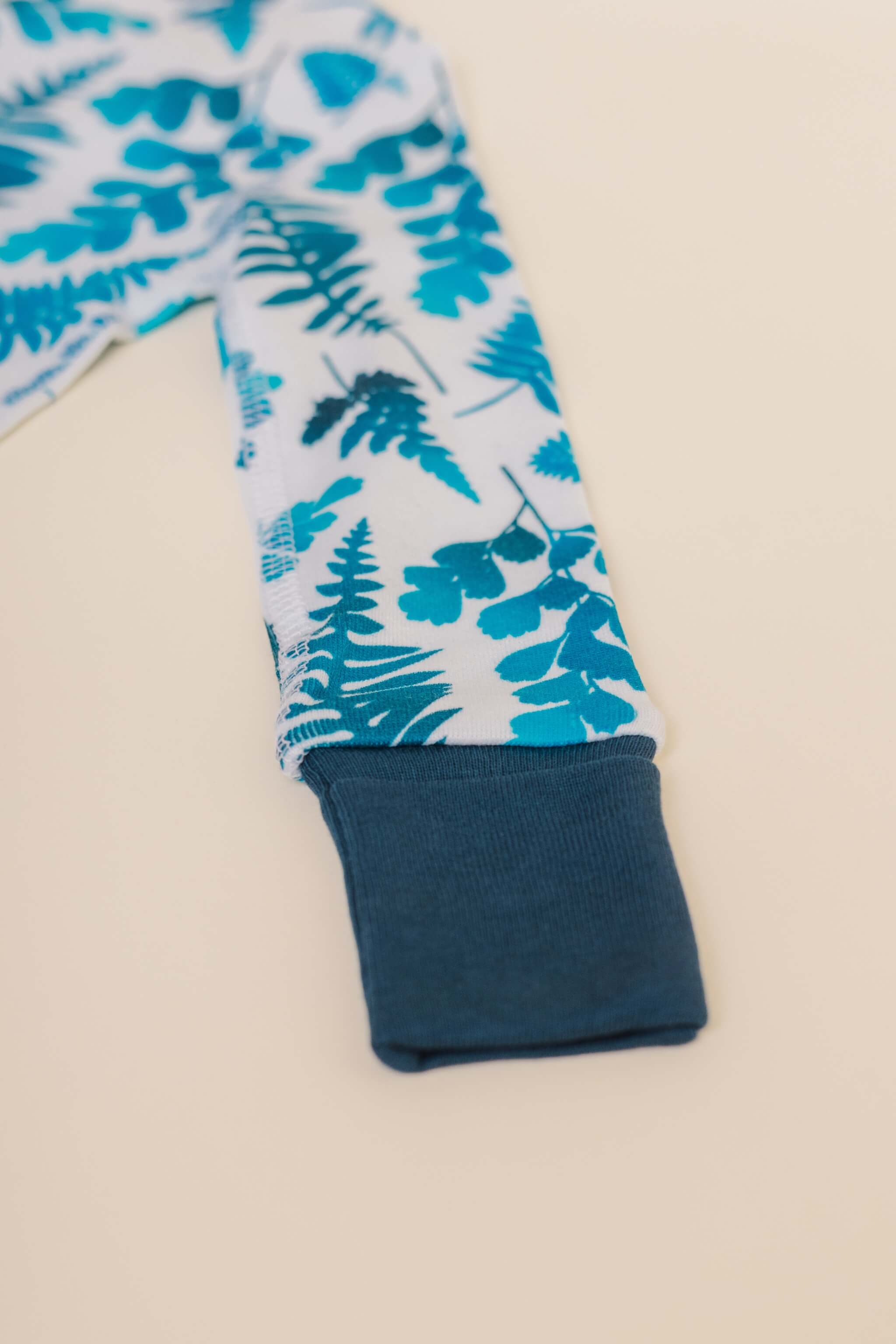 organic cotton baby zipper sleeper with fold-over cuffs in blue fern print designed by jen johnston