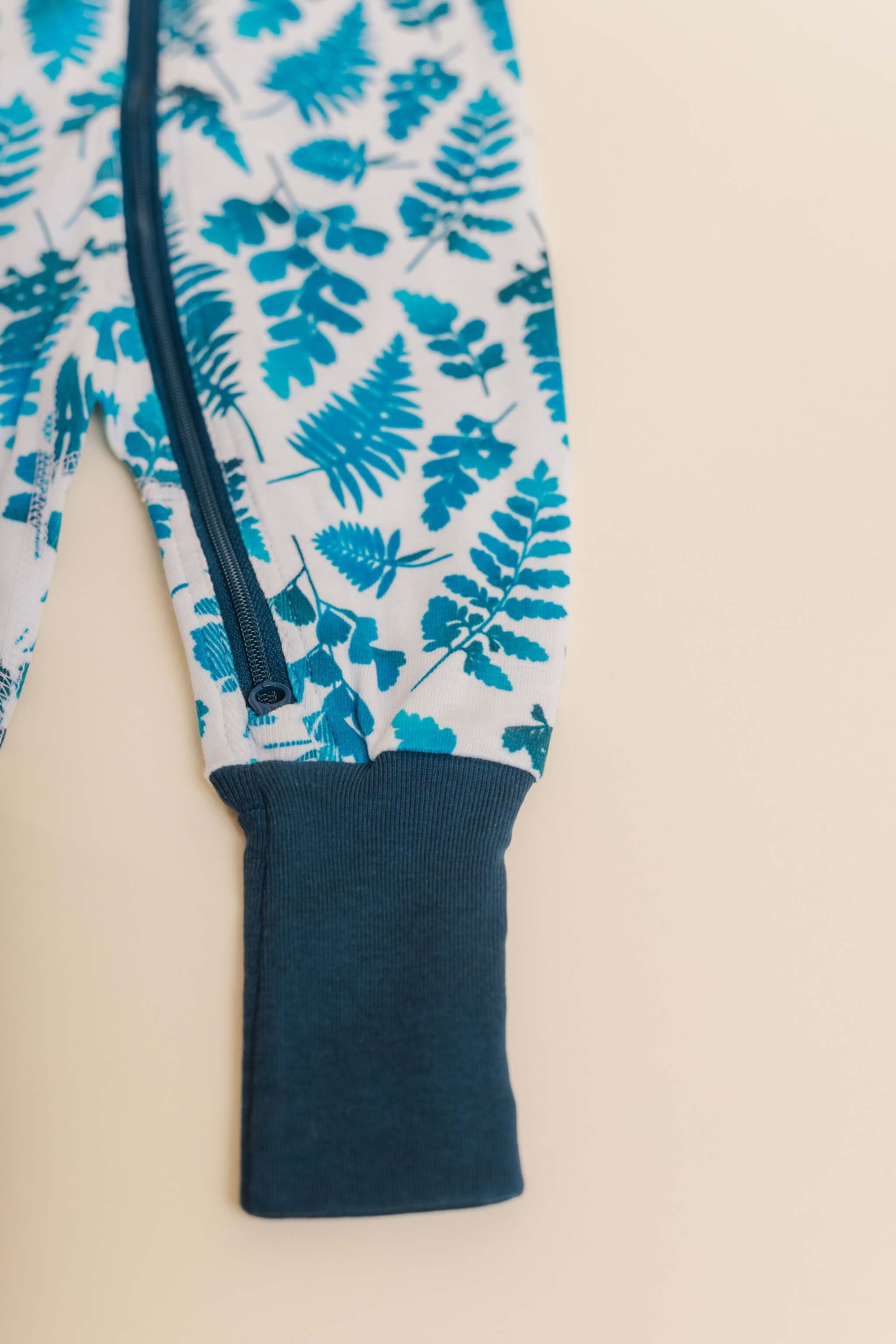 organic cotton baby zipper sleeper with fold-over cuffs in blue fern print designed by jen johnston