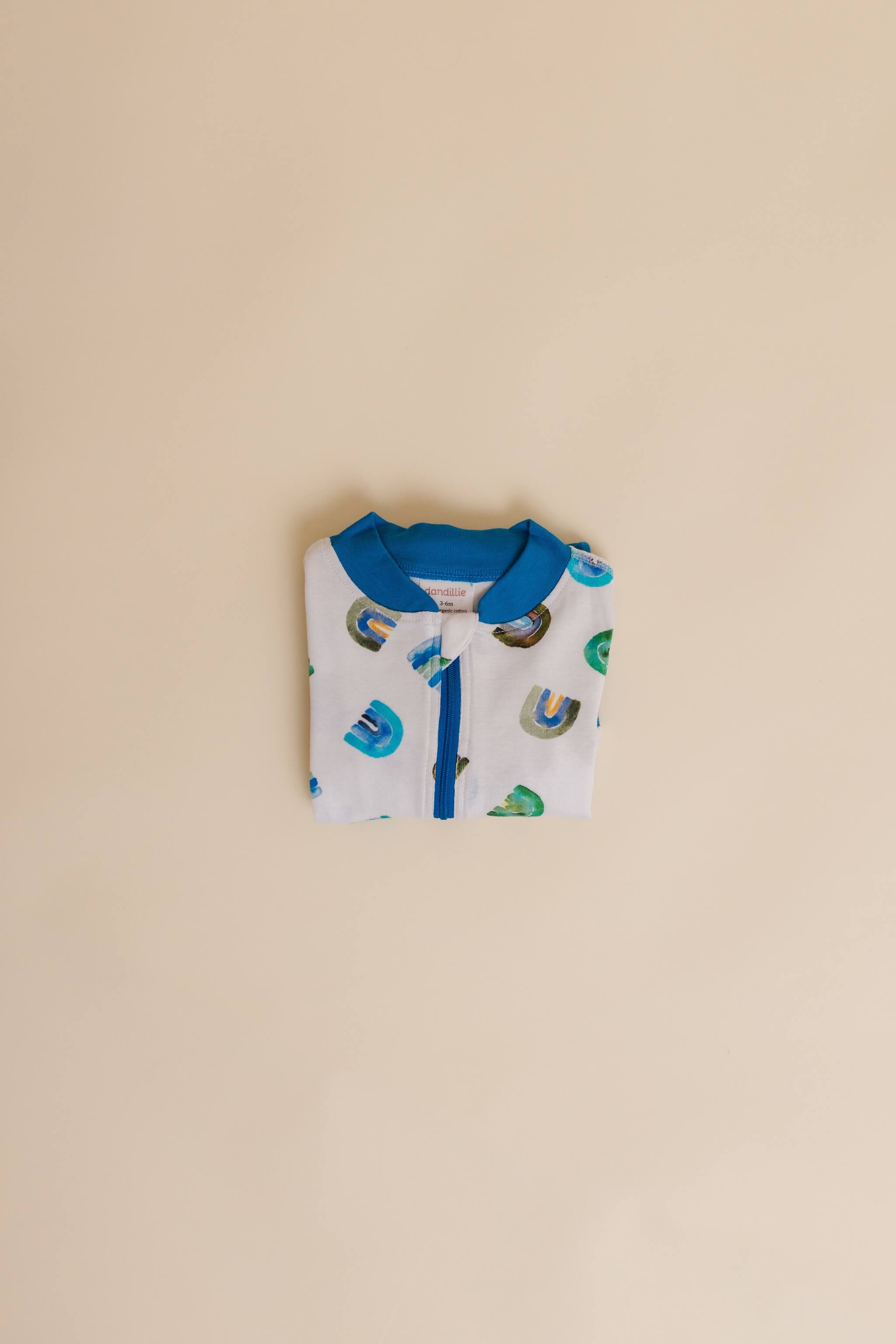 organic cotton baby zipper sleeper with fold-over cuffs in blue rainbow print designed by madeline kerrii