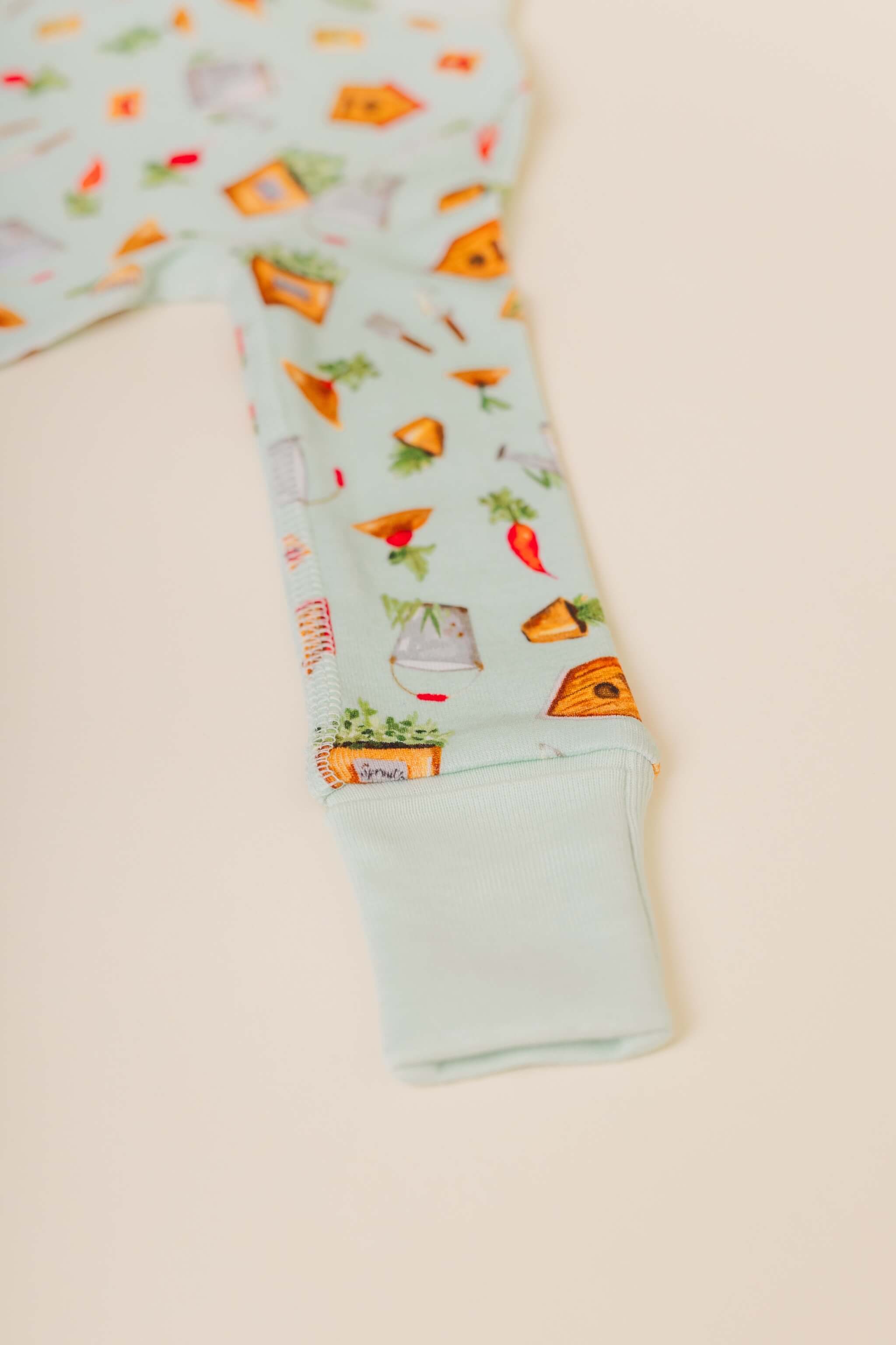 organic cotton baby zipper sleeper with fold-over cuffs in green garden print designed by cris rogerson