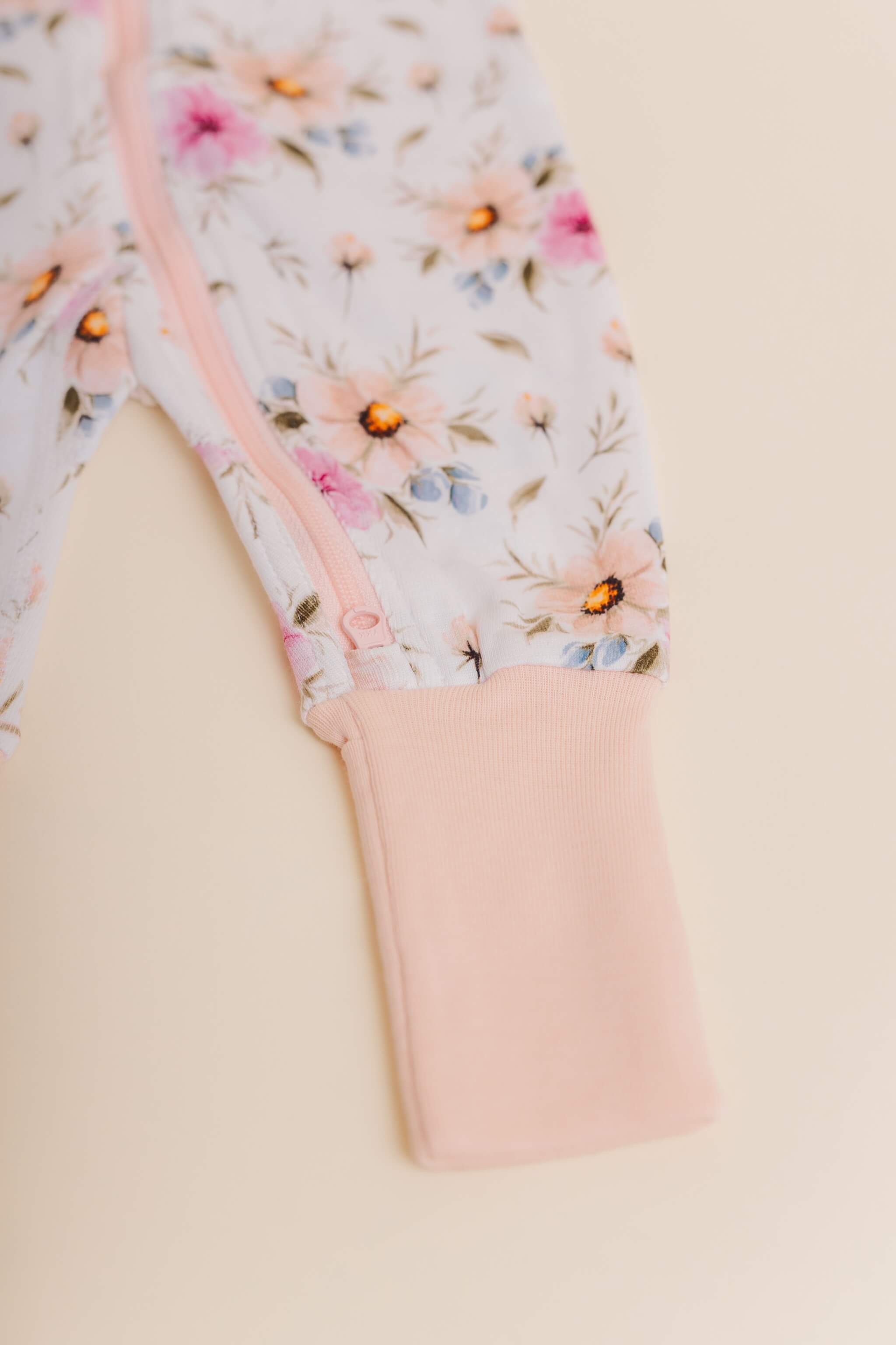 organic cotton baby zipper sleeper with fold-over cuffs in coral floral print designed by jen sweeney
