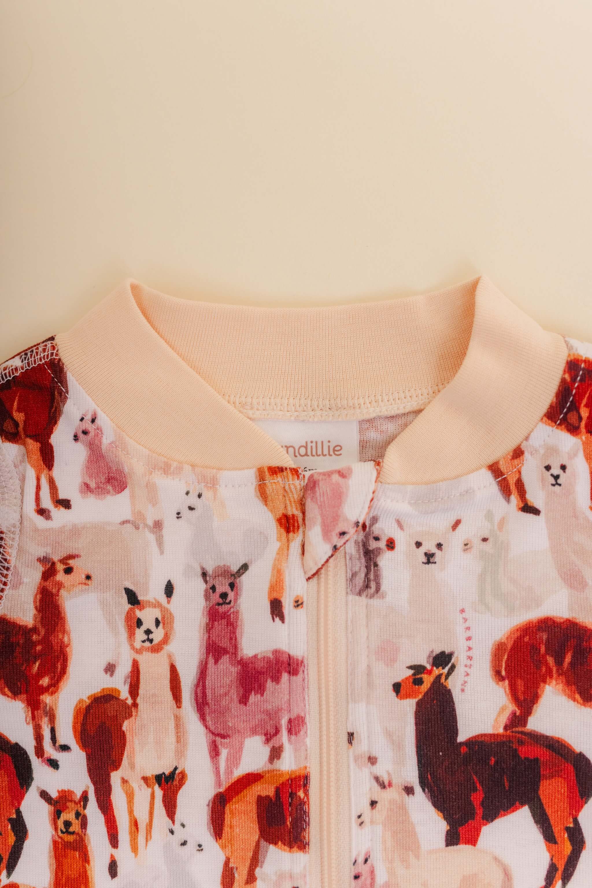 organic cotton baby zipper sleeper with fold-over cuffs in tan alpaca print designed by barbra ignatiev
